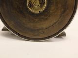 a metal object that is sitting on a white surface
