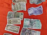 several bills are laid out on a red cloth on a table