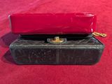 a black and red purse sitting on a red surface