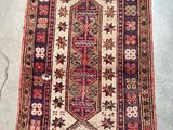 Un vieux tapis est posé par terre à côté d'une paire de ciseaux.