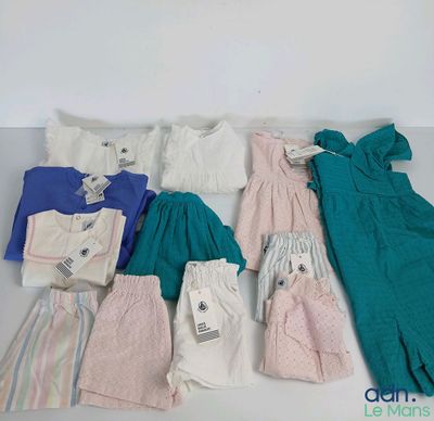 beaucoup de vêtements pour bébés et d'autres vêtements à vendre sur une table