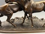 une statue en bronze représentant deux chevaux sur un rocher
