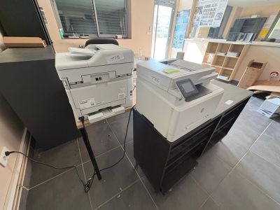 deux imprimantes posées sur un bureau dans une pièce