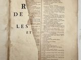 an old open book with a torn page on top of it