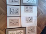 many framed pictures on the wall of a room