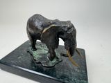 statue of an elephant with tusks on a marble base