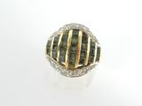 un gros plan d'une bague sertie de diamants sur une surface blanche