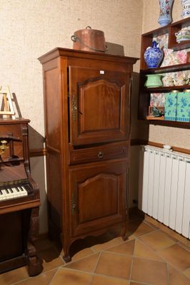 un piano et une armoire dans un coin de la pièce