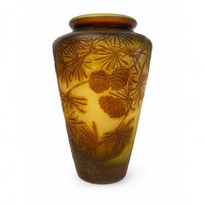 un vase marron orné de pommes de pin sur fond blanc