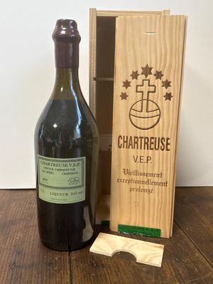 une bouteille de vin dans un coffret en bois, à côté d'une autre bouteille de vin