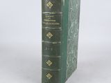 un livre vert posé sur une table blanche