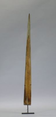a tall wooden object on a metal stand on a white surface