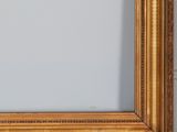 an antique gold frame with a white wall in the background