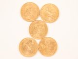 four gold coins are arranged in a row on a white surface