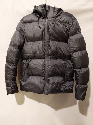 a black jacket hanging on a hanger against a white wall