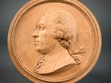 portrait of a man in profile on a circular plaque