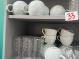 many cups and saucers on the shelves in the kitchen