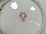 a white plate with a red stamp on it in someone ' s hand