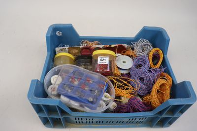 un bac en plastique bleu rempli de laine et d'autres objets
