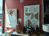 une table sur laquelle se trouvent des vases et un tableau, placée devant une fenêtre