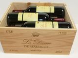 bottles of red wine in a wooden box on a white surface