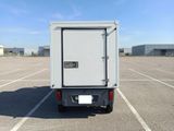 a small white box truck parked in a parking lot