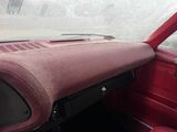 dashboard of a red car with a dirty cloth covering the dash