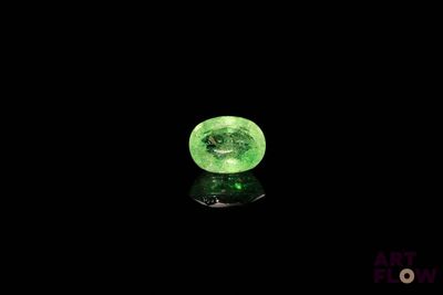 un gros plan d'une boule de verre verte posée sur une surface noire