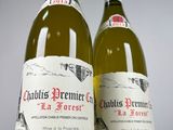two bottles of white wine sitting next to each other on a table