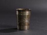 a metal cup with a design on it sitting on a table