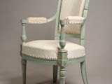 an old chair with a white upholstered seat on a gray background