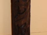 a wooden vase with carvings on it in a room