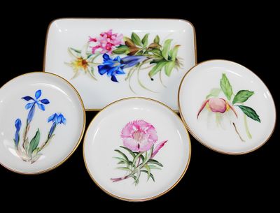 quatre assiettes ornées de fleurs peintes sur un fond noir
