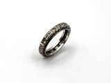 un gros plan d'une bague sertie de diamants noirs sur fond blanc