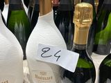 Des bouteilles de vin sont alignées sur une table, accompagnées d'une étiquette de prix