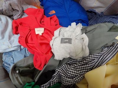 a pile of clothes sitting on a bed with a tag on it