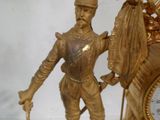 une horloge en or avec une statue d'homme à cheval