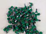 un tas de Lego verts posé sur une surface blanche