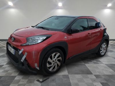 La Toyota C-HR rouge est garée sur un sol à damier.