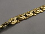 a close up of a gold bracelet on a gray surface