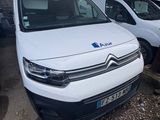 une camionnette blanche garée dans un parking à côté d'autres voitures