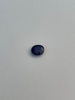a close up of a blue sapphire stone on a white surface