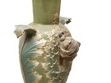 a green vase with a fish on it on a white background