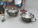 a silver tray with a teapot, a bowl, and a dog figurine on it