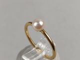 a close up of a gold ring with a pearl on top