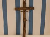 a cross on a table with a striped wall behind it