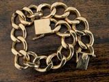a gold chain bracelet with a padlock on top of it