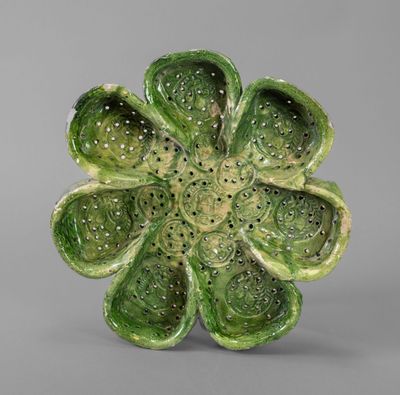 a close up of a green flower on a gray surface