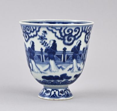tasse en porcelaine bleue et blanche représentant des personnages dans un paysage