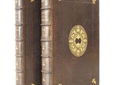 an old book with a gold medallion on the cover